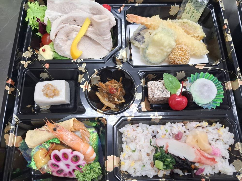 秋柄の器に詰めた折詰。炊き込みご飯、豚しゃぶ、天ぷら、胡麻豆腐、デザート